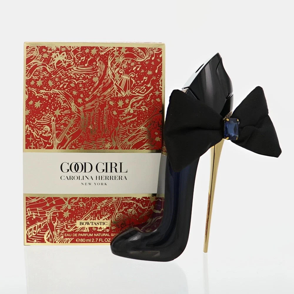 Black high-heeled shoes with a bow next to a 'Good Girl' Carolina Herrera perfume box.